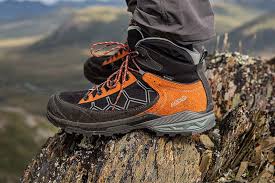 Three pairs of hiking boots on a wooden surface